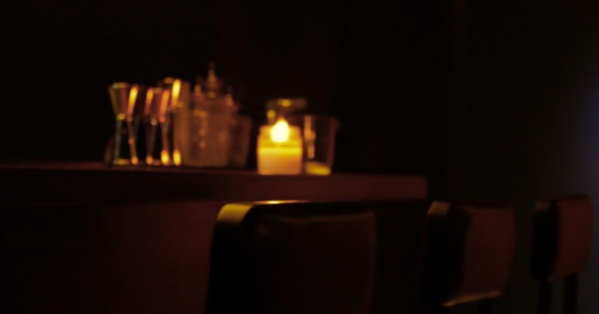 Moody bar ambiance with candlelight and barware at Blue Door 304